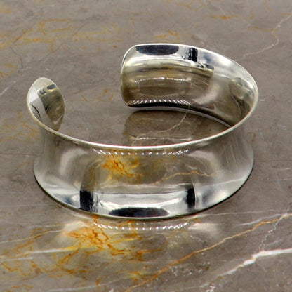Shiny 925 sterling silver cuff bracelet with a curved, trendy design, featuring elegant tribal-inspired details.