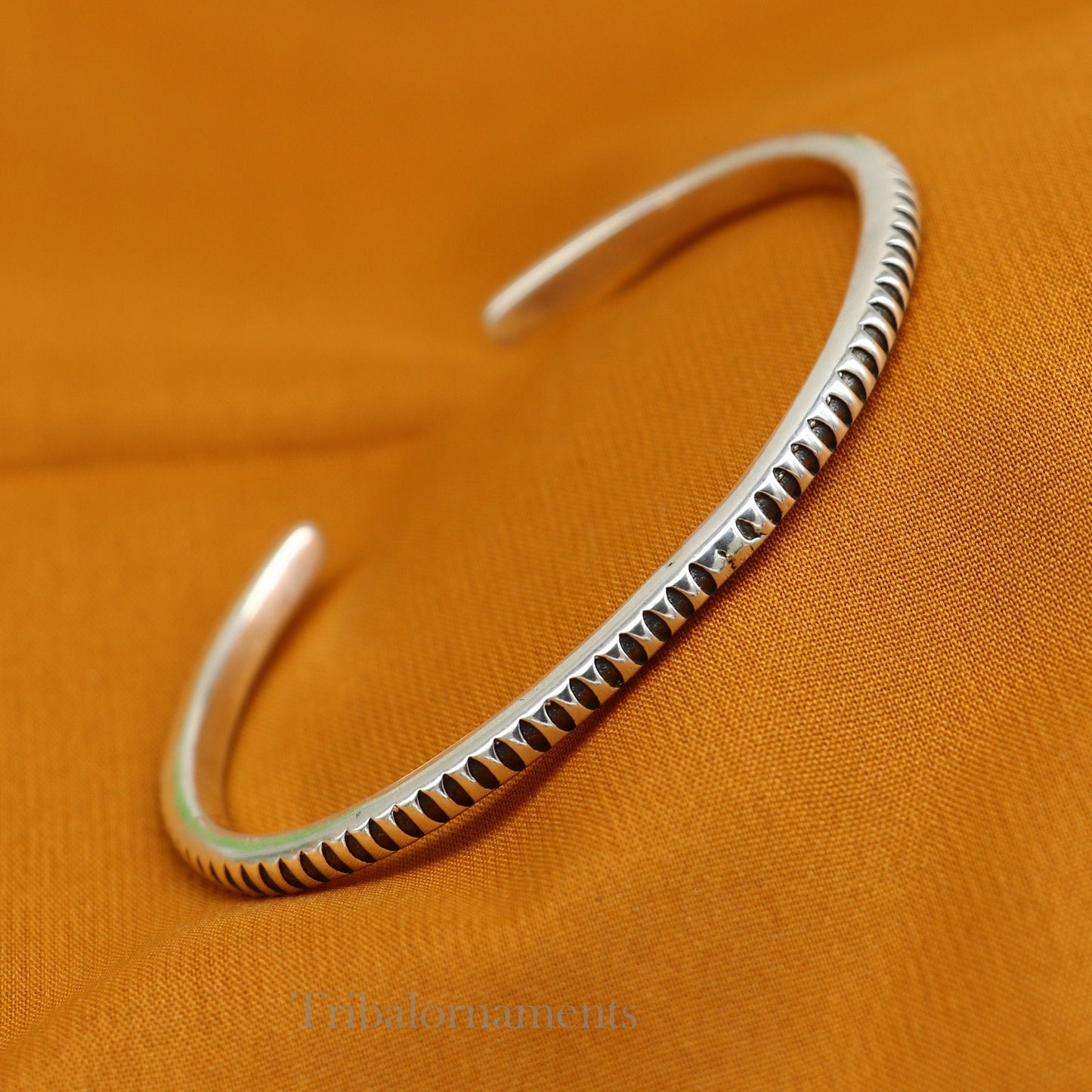 Sterling silver adjustable cuff bangle bracelet by Tribal Ornaments, unisex handmade jewelry with intricate tribal detailing.