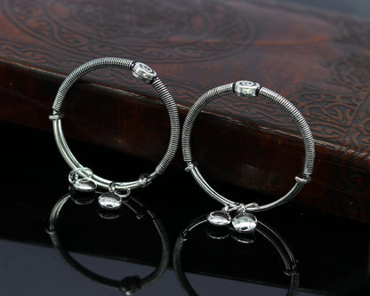 Sterling silver designer baby adjustable bangle bracelet with intricate tribal patterns and charm details, perfect for kids jewelry.