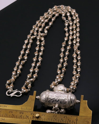 Sterling silver amulet pendant with hanging bells and basil rosary beads, part of a tribal jewelry set from India.