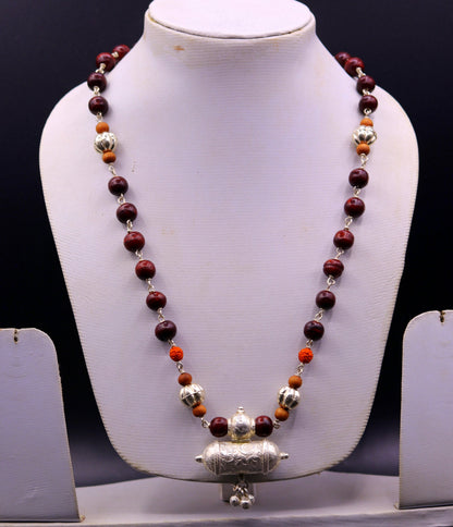 Vintage tribal silver necklace set with sandalwood, Rudraksha beads, amulet pendant, and hanging bells by TRIBAL ORNAMENTS.