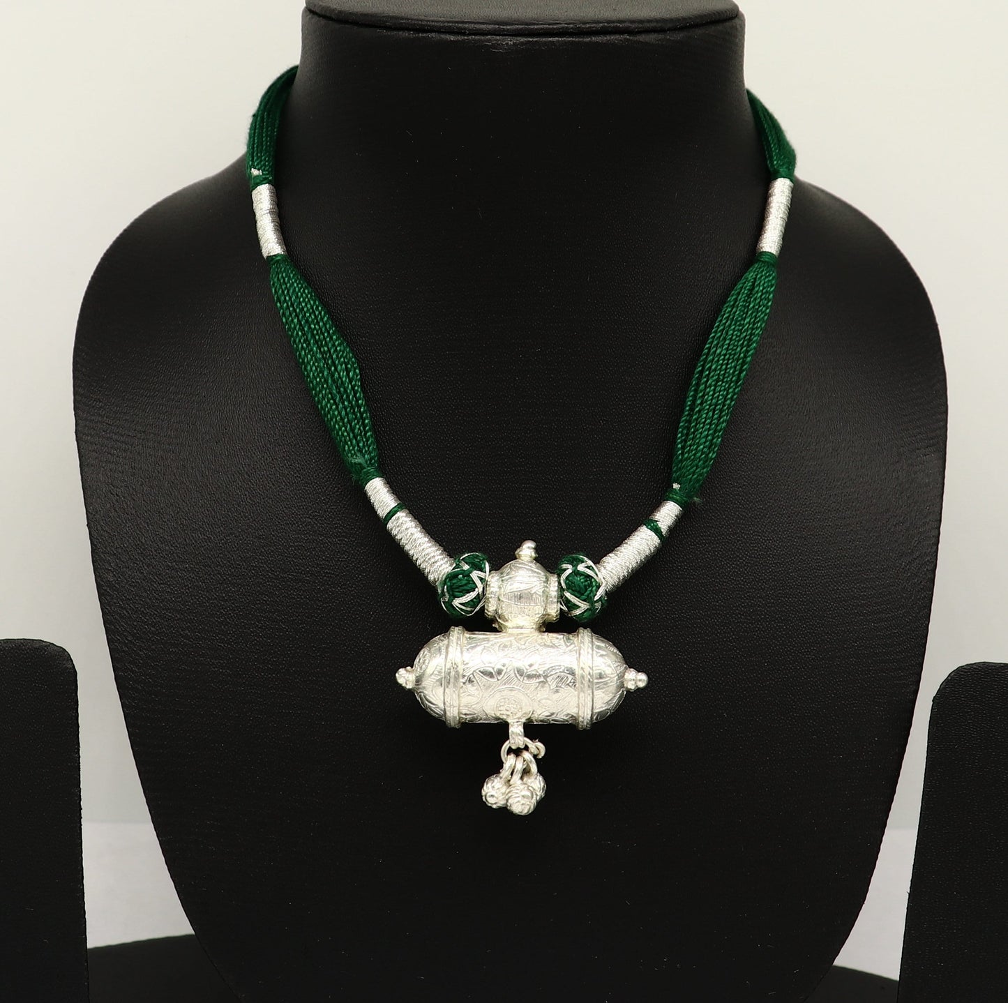 Vintage Indian silver charm necklace with green thread, traditional tribal design, perfect for brides and ethnic wedding jewelry.