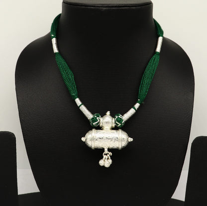 Vintage Indian silver charm necklace with green thread, traditional tribal design, perfect for brides and ethnic wedding jewelry.