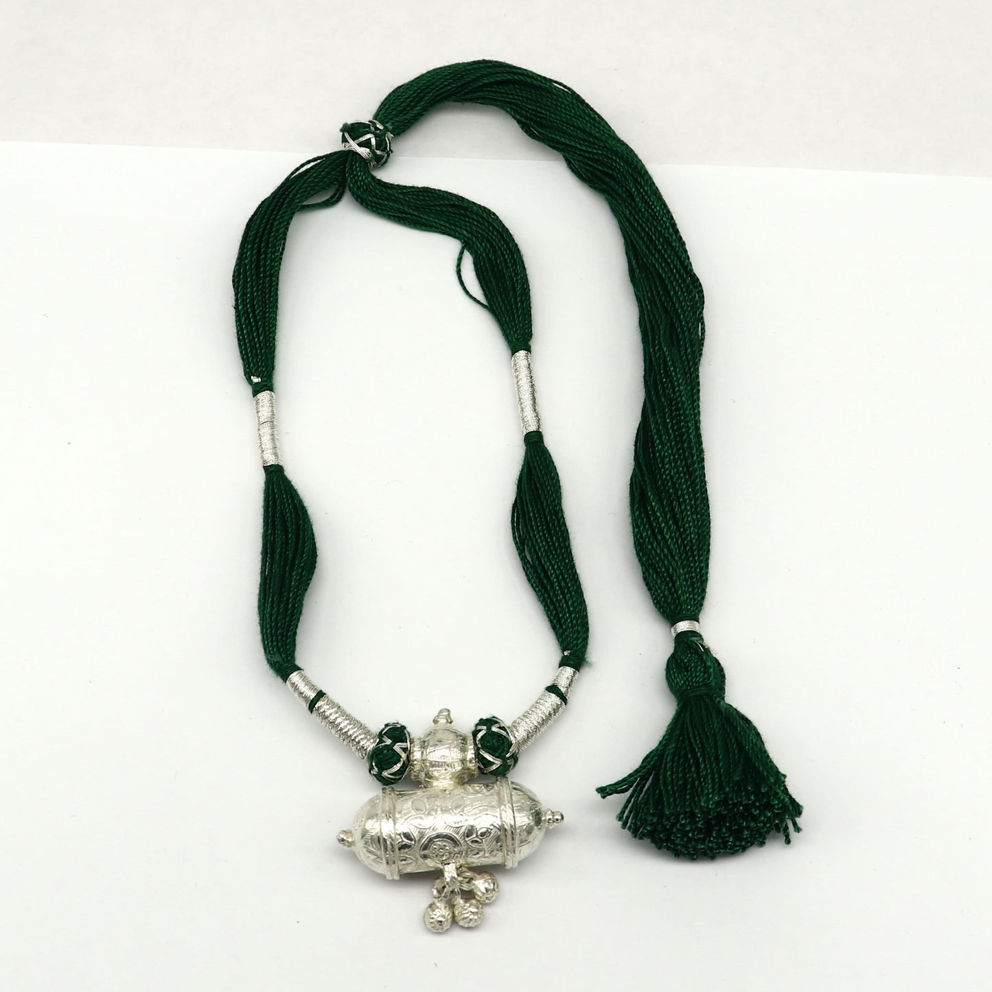 Vintage Indian tribal silver charm necklace with green thread, traditional wedding jewelry set featuring ethnic design and intricate detailing.