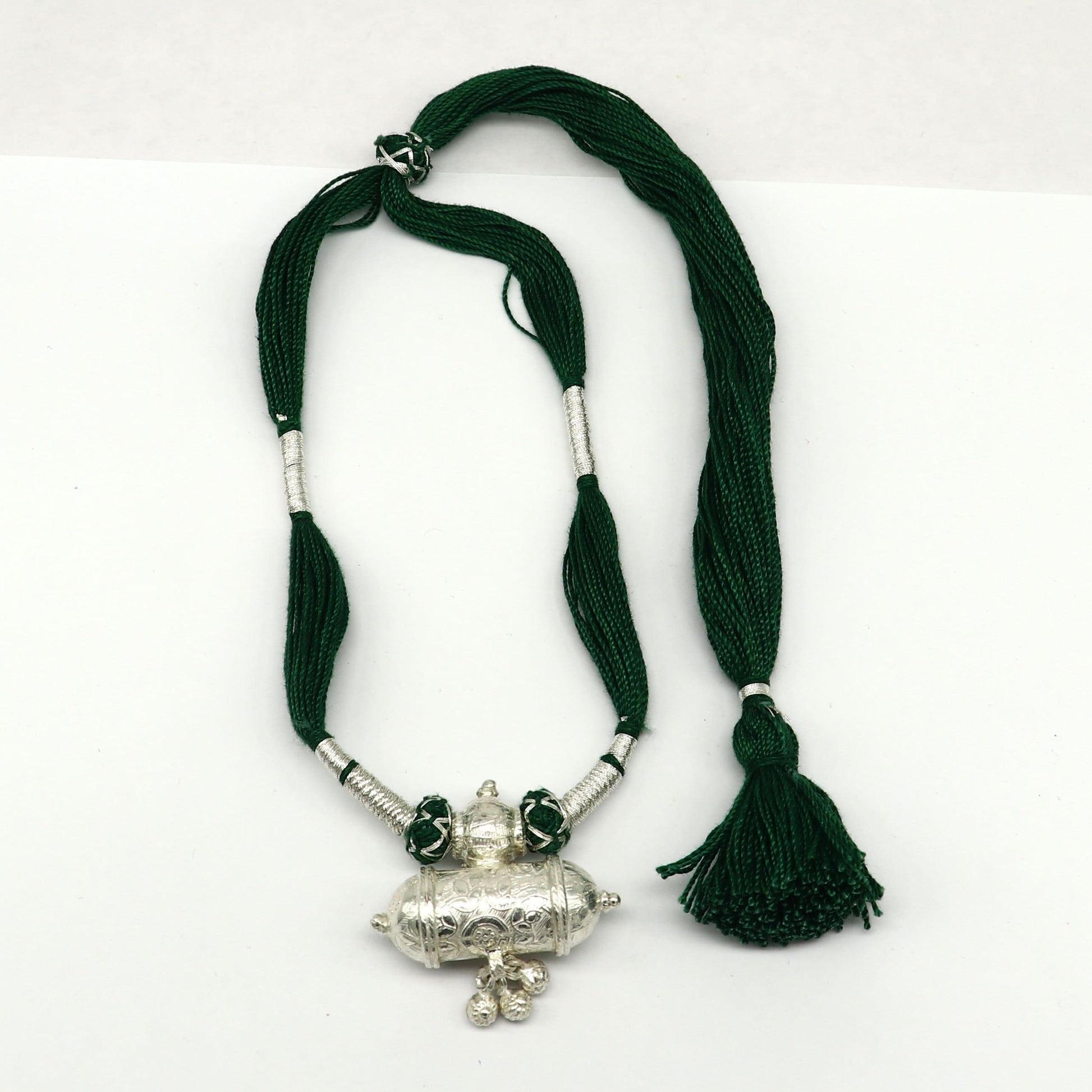 Vintage Indian tribal silver charm necklace with green thread, traditional wedding jewelry set featuring ethnic design and intricate detailing.