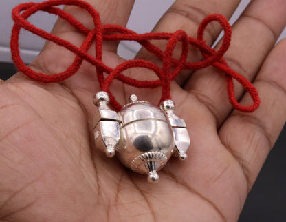 Handmade silver Shiva pendant in vintage mantra box, tribal jewelry container with intricate tribal ornament design.