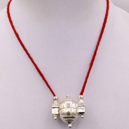 Handmade silver Shiva pendant in a vintage mantra box, tribal jewelry container with intricate tribal ornament details.
