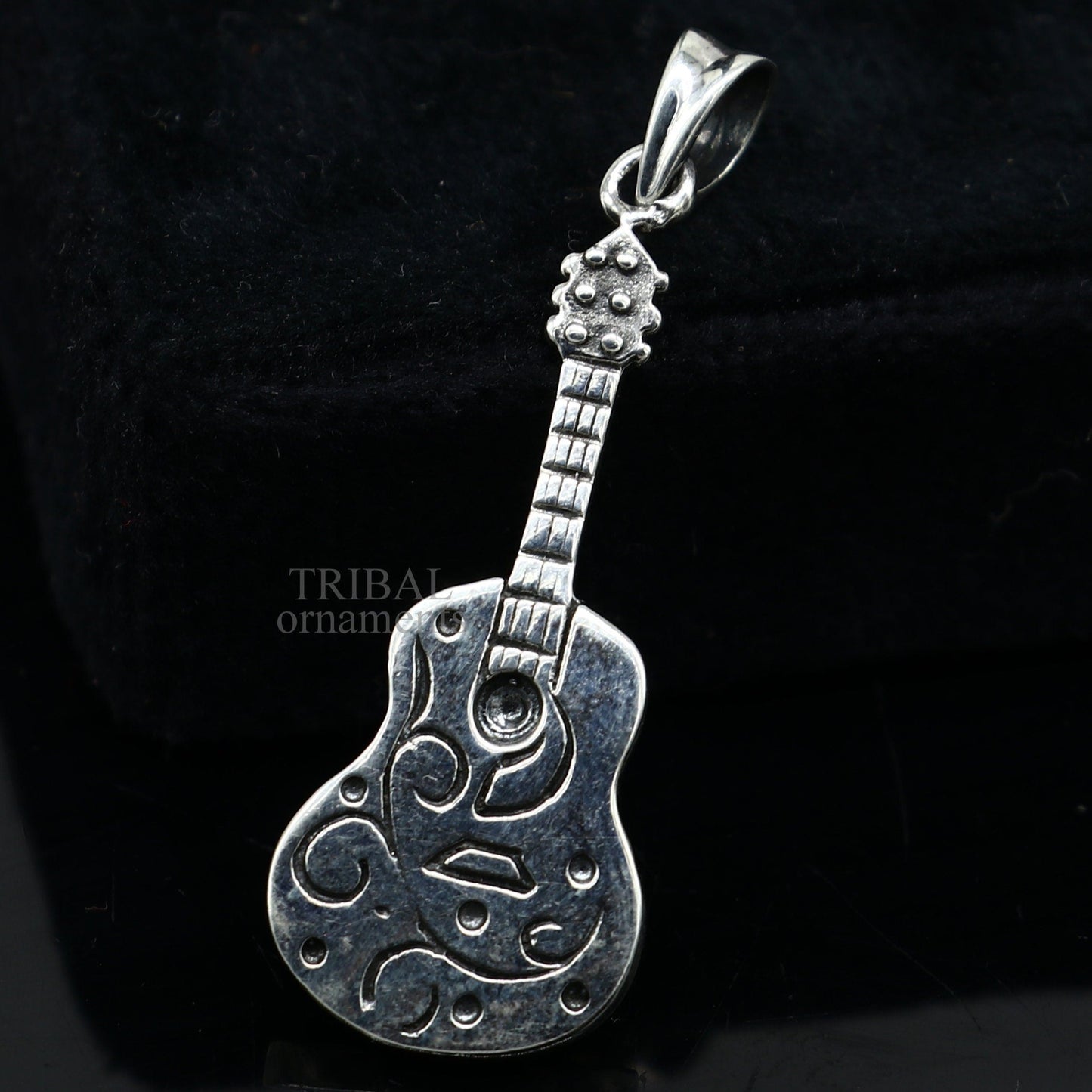 Sterling silver guitar pendant from TRIBAL ORNAMENTS, handcrafted unisex jewelry with a detailed small guitar design.