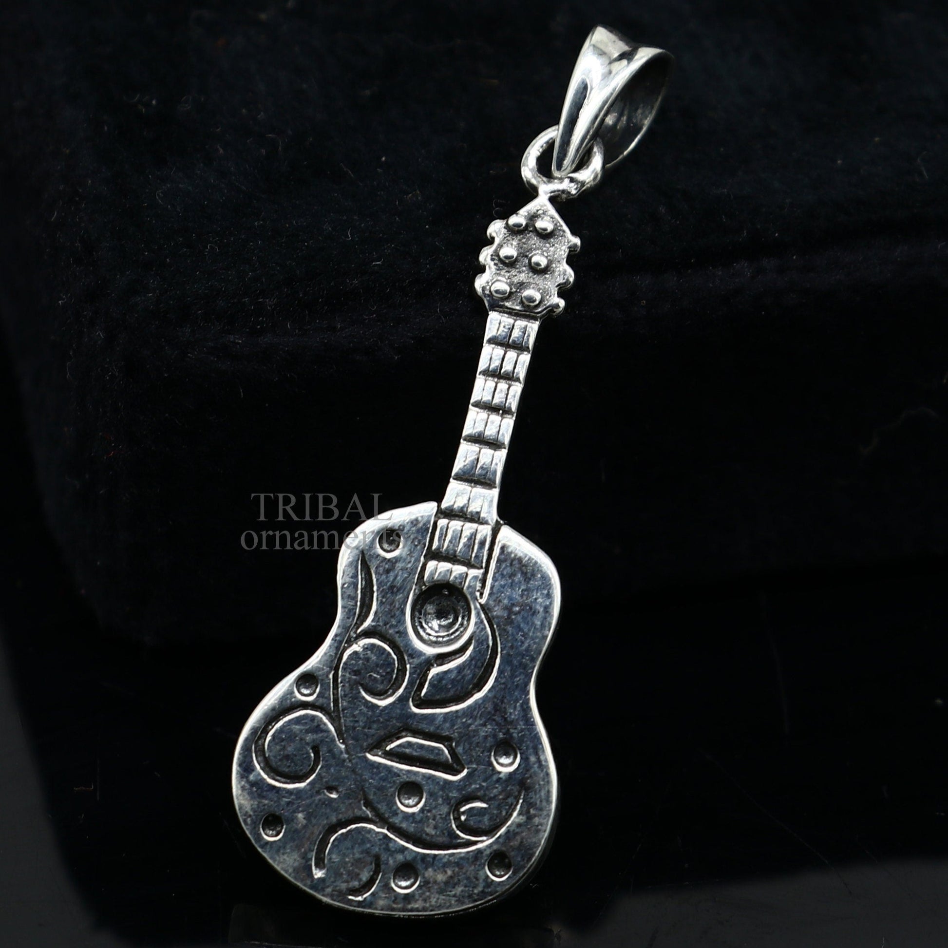 Sterling silver guitar pendant from TRIBAL ORNAMENTS, handcrafted unisex jewelry with a detailed small guitar design.