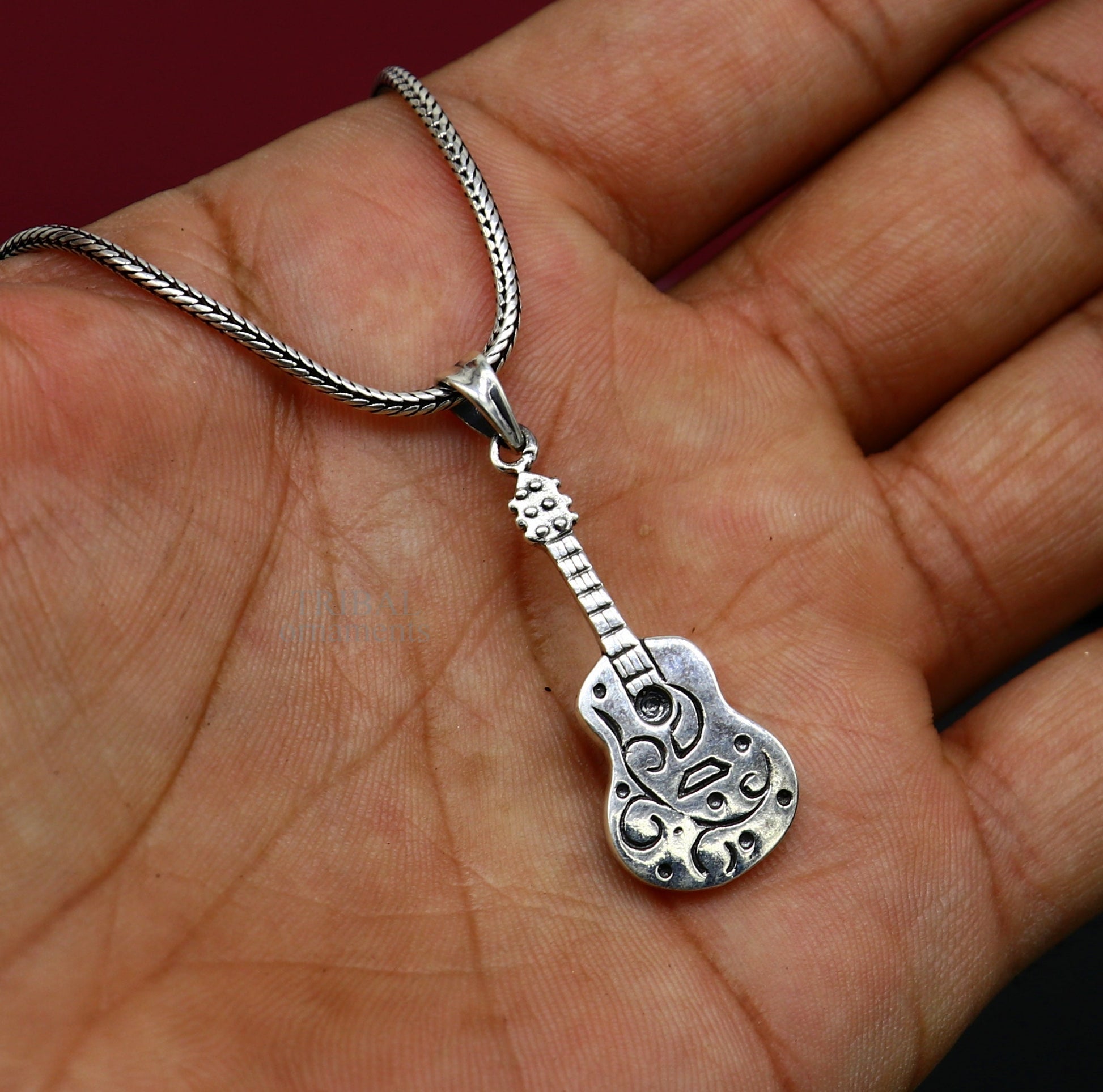 Sterling silver guitar pendant by Tribal Ornaments, unisex handmade jewelry with tribal-inspired small guitar design.