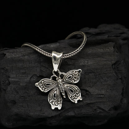 Sterling silver butterfly and bird pendant by TRIBAL ORNAMENTS, handmade unisex jewelry featuring delicate butterfly design.