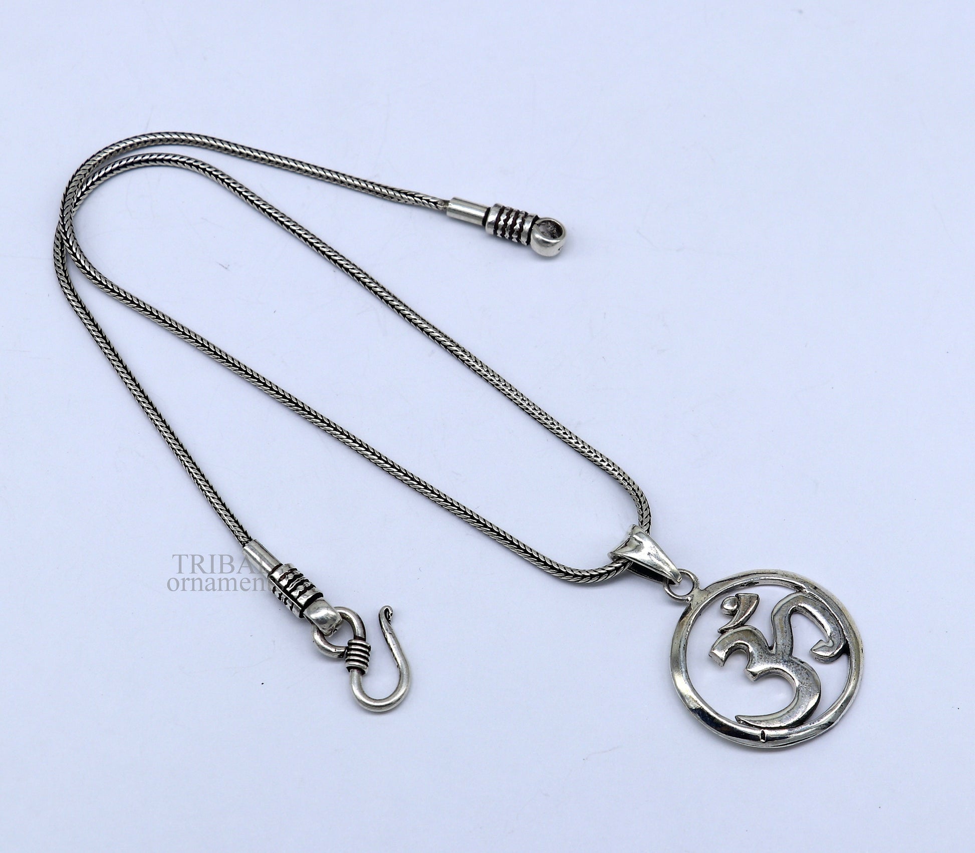 Sterling silver Hindu mantra Aum OM pendant by TRIBAL ORNAMENTS, featuring intricate tribal design and personalized good luck symbol.