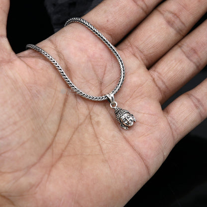 925 silver Lord Buddha face pendant by TRIBAL ORNAMENTS, close-up view showing intricate Buddha facial details and smooth silver finish.