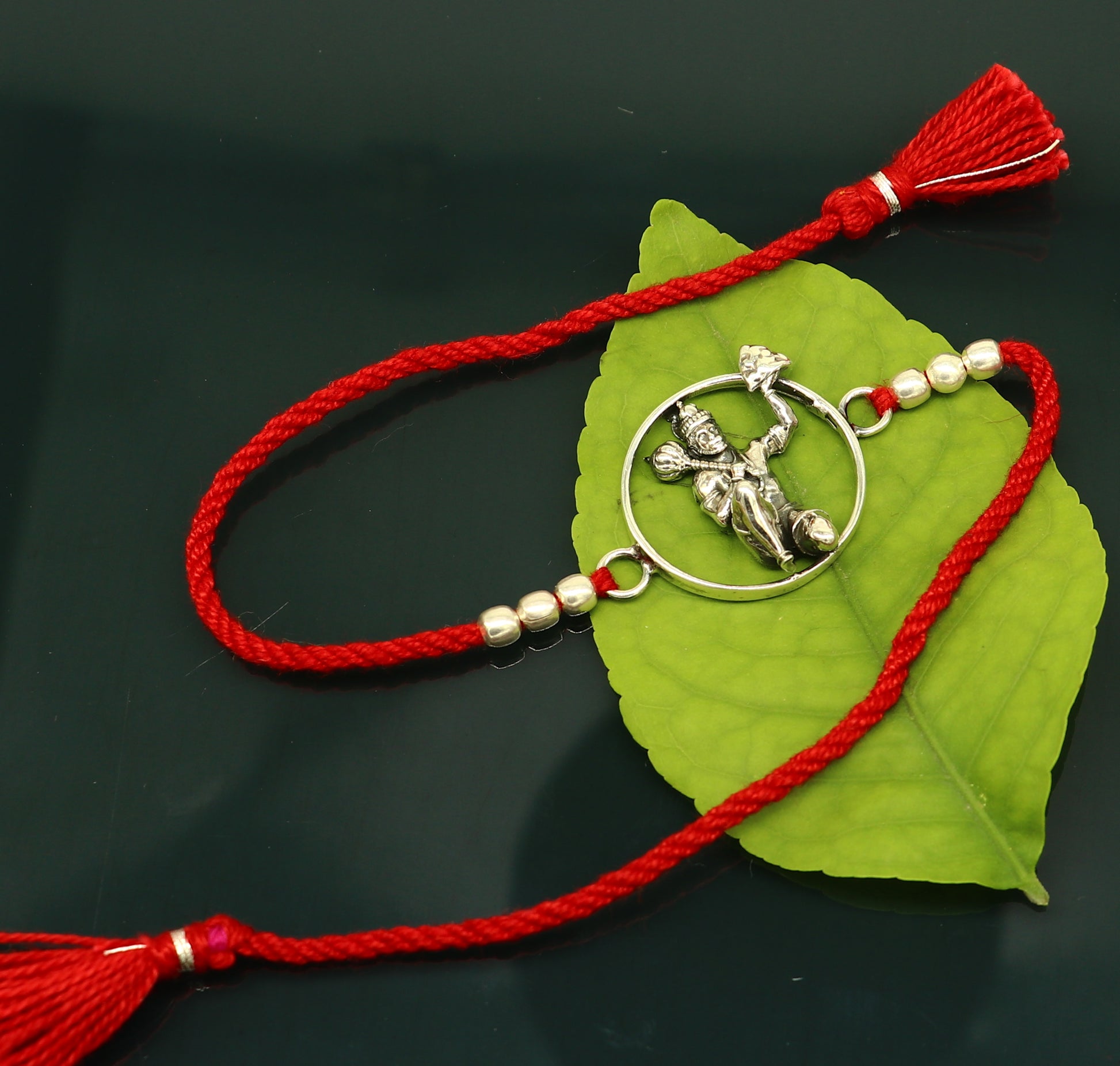 925 sterling silver Hanuman design bracelet with red thread rakhi, featuring intricate tribal ornament craftsmanship and traditional style.
