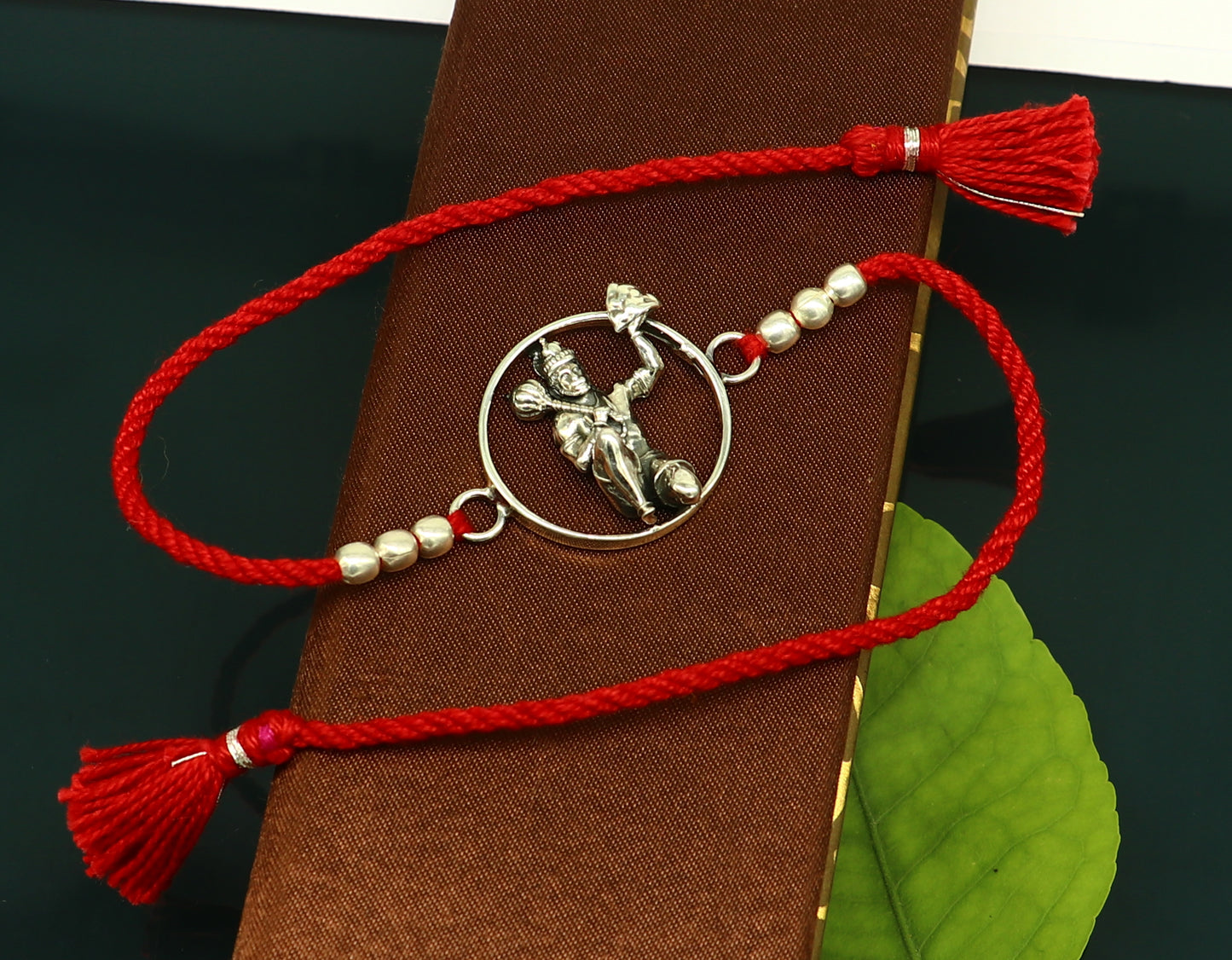 Sterling silver Hanuman bracelet with red thread Rakhi from Tribal Ornaments, featuring intricate god Hanuman design.