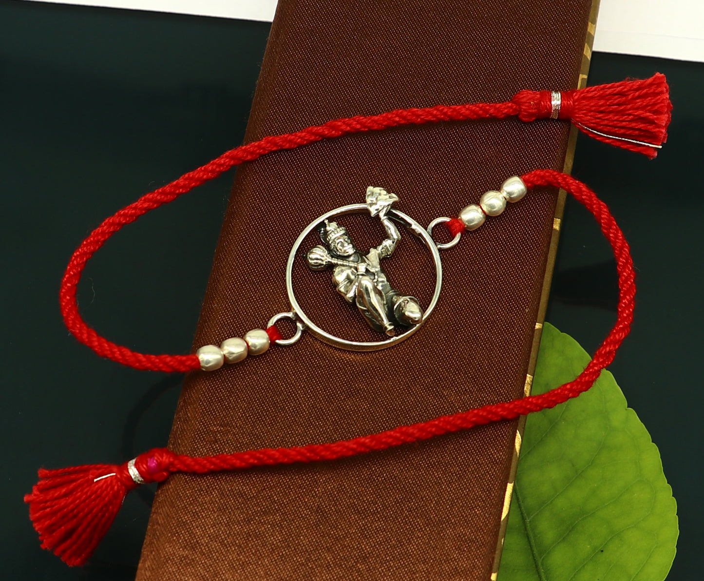 Sterling silver Hanuman bracelet with red thread Rakhi, featuring intricate tribal design by Tribal Ornaments, model RK172.