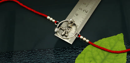 925 sterling silver Hanuman design bracelet with red thread rakhi, featuring intricate tribal ornament craftsmanship.