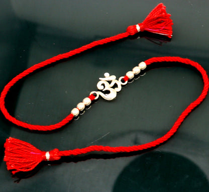 Sterling silver OM symbol bracelet with red thread, custom design, tribal ornaments rakhi featuring traditional spiritual motif.