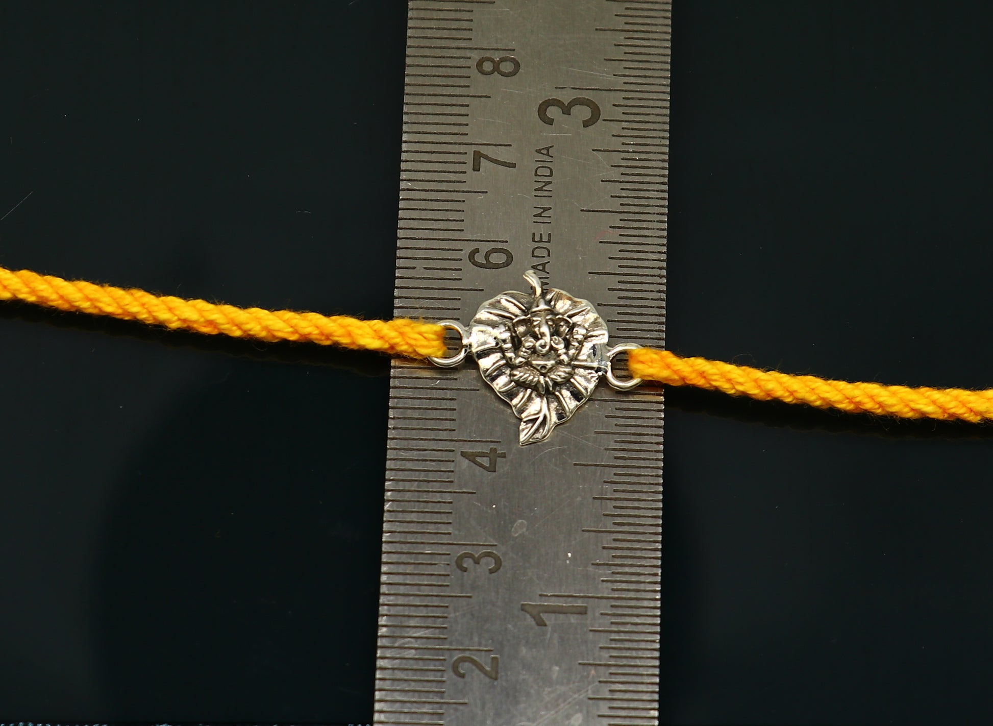 925 sterling silver Ganesha bracelet with yellow thread, traditional Rakhi design by Tribal Ornaments.