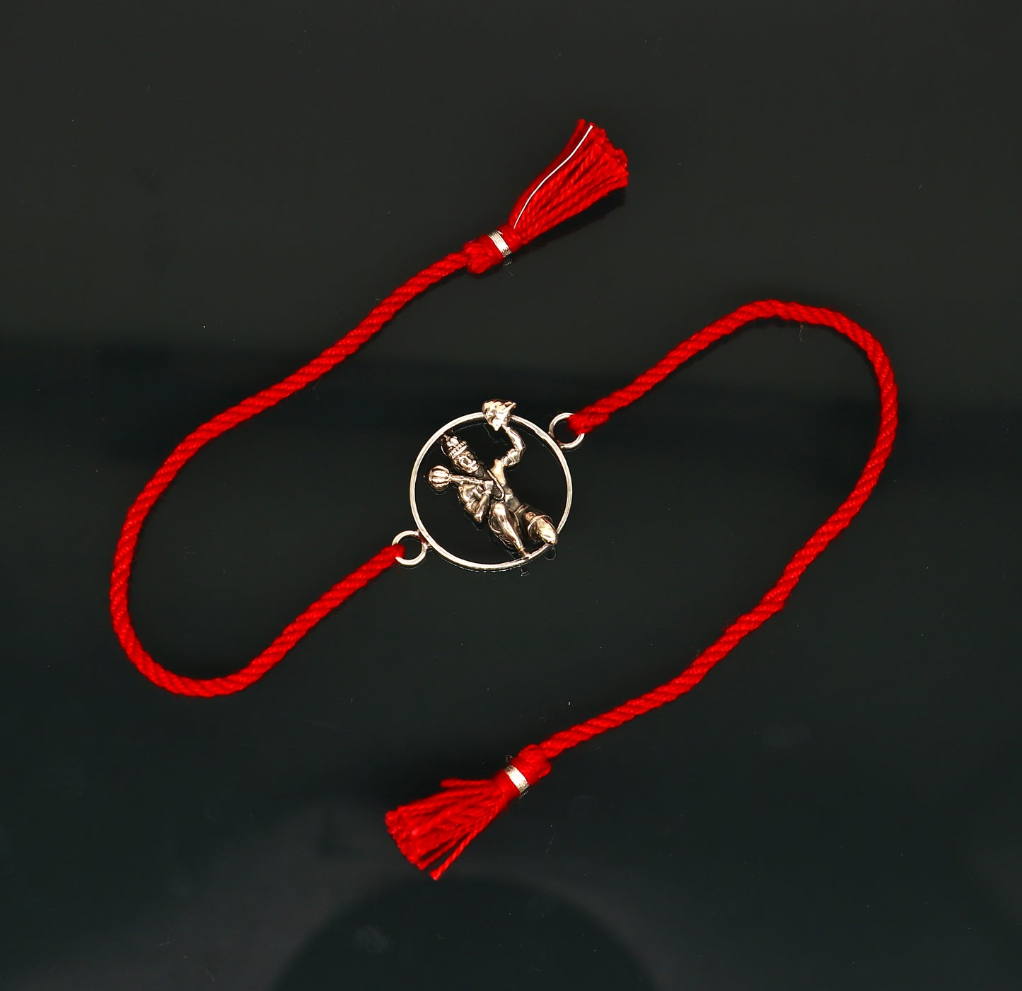 925 sterling silver Hanuman idol bracelet with red thread rakhi from Tribal Ornaments, featuring intricate design and vibrant red thread.