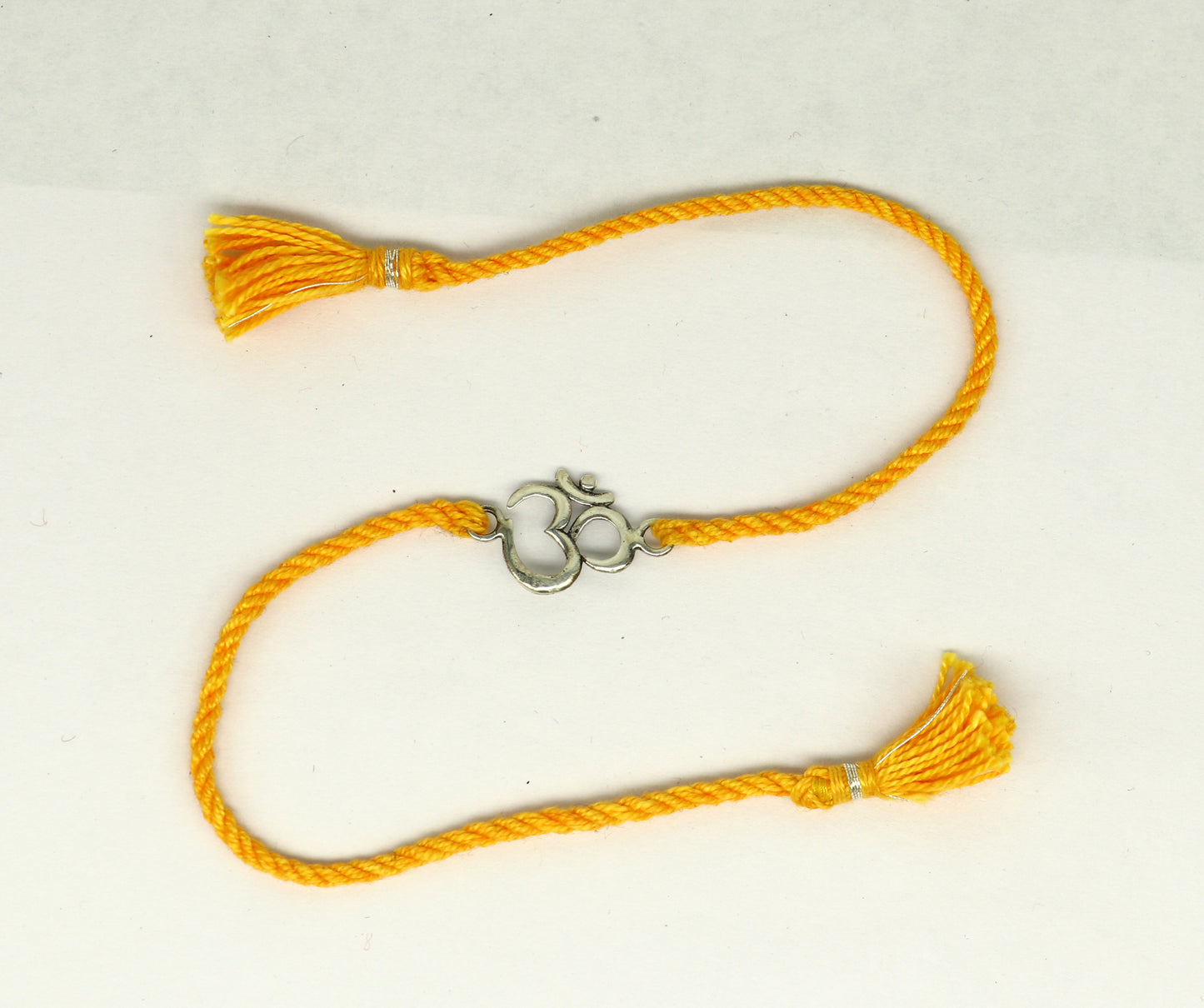 925 sterling silver OM design bracelet Rakhi with yellow thread, featuring custom tribal ornament style and intricate Aum motif.