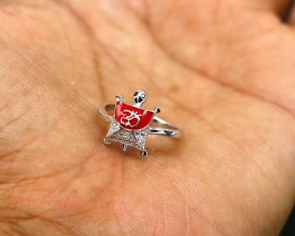Red sterling silver tortoise ring with OM symbol, featuring an AD stone, elegant unisex design, by TRIBAL ORNAMENTS.