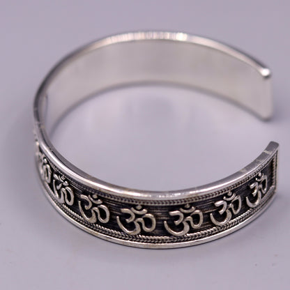 Sterling silver or gold polished 'AUM' mantra bangle bracelet by TRIBAL ORNAMENTS, handcrafted unisex ethnic jewelry from India.