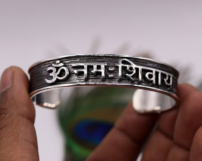 Sterling silver open face cuff bracelet engraved with "Aum namah shivay" by Tribal Ornaments, polished silver or gold finish.