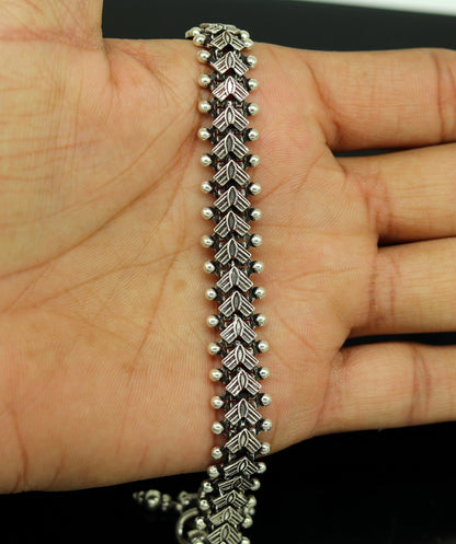 Traditional Indian 925 Sterling silver anklet with intricate tribal design, worn on a woman's foot, showcasing chunky jewelry style.