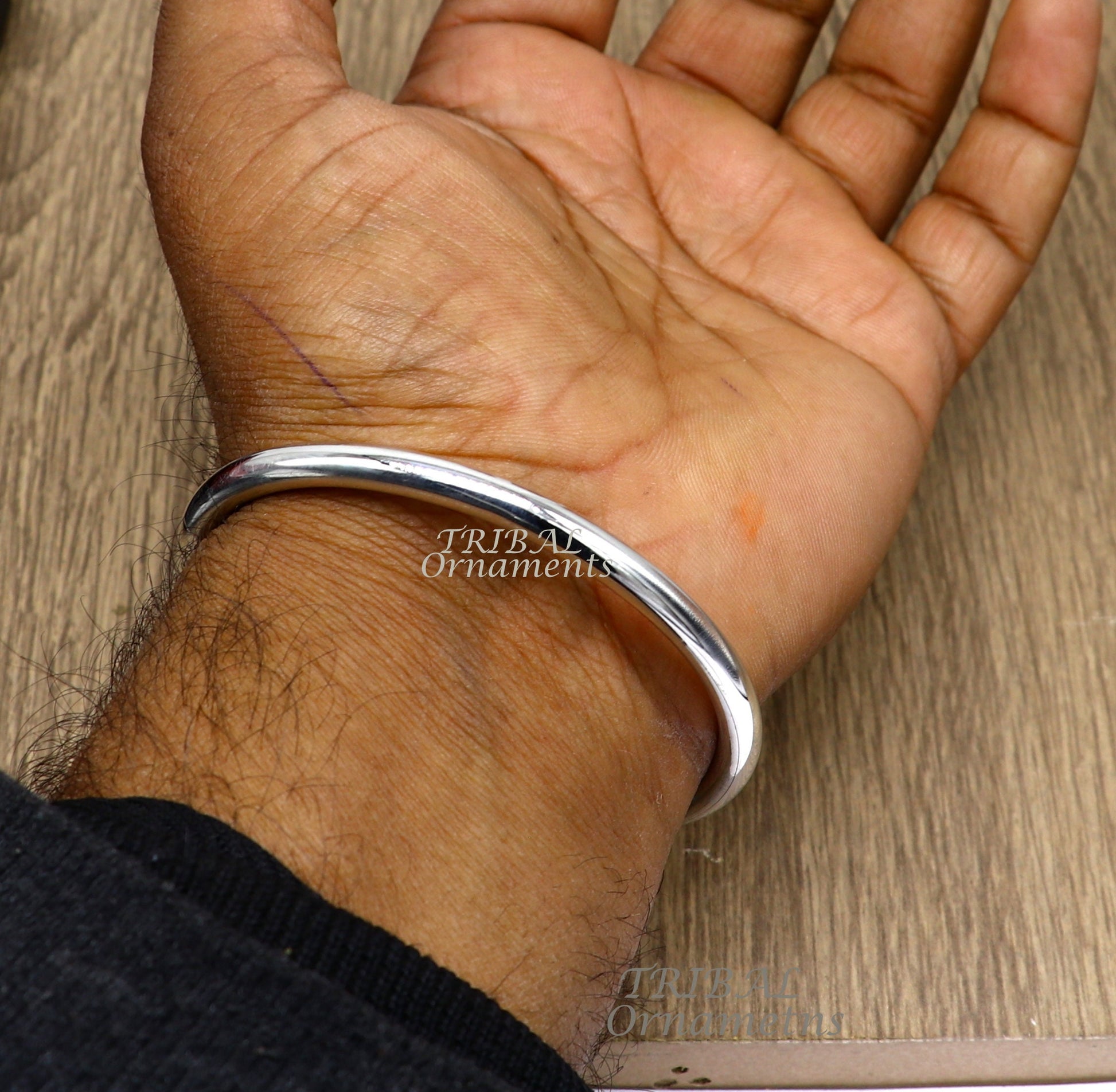 Sterling silver handmade bangle bracelet by TRIBAL ORNAMENTS, shiny, plain, customized unisex jewelry for gifting or everyday wear.