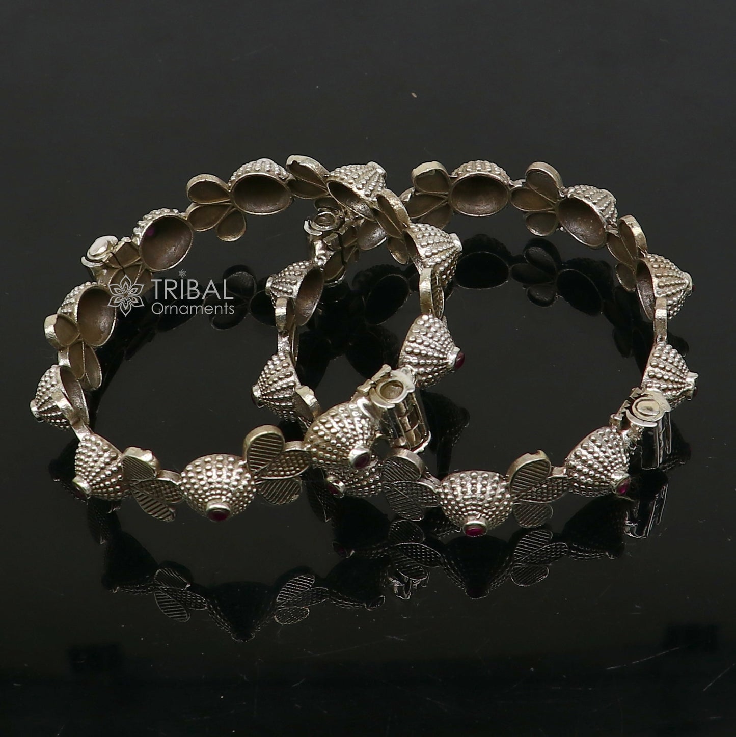 Sterling silver tribal bangle bracelet with red stone accents, featuring intricate cultural design and trendy wedding jewelry style.